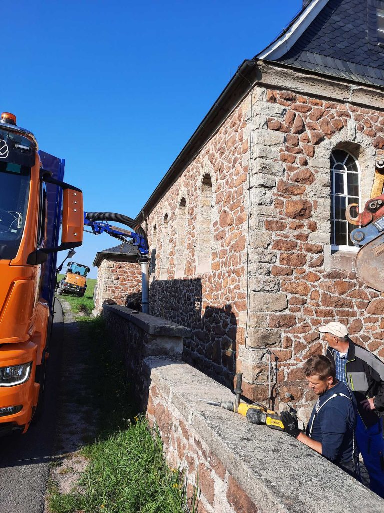 Saugbagger: Freilegung einer Mauer an einer Kirche unter Denkmalschutz